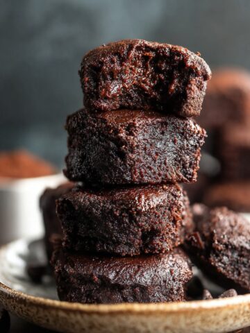 Healthy Date Brownies Recipe 1 A stack of freshly baked, fudgy Date Brownies, with a rich, dark chocolatey interior. The brownies are moist and soft, with one slice taken to show the texture.