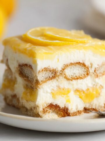 No-Bake Lemon Tiramisu Recipe 2 A slice of Lemon Tiramisu with layers of ladyfingers, creamy mascarpone, and lemon syrup, topped with lemon slices.
