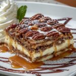 Image of a slice of Pecan Pie Lasagna topped with whipped cream and pecans on a plate.