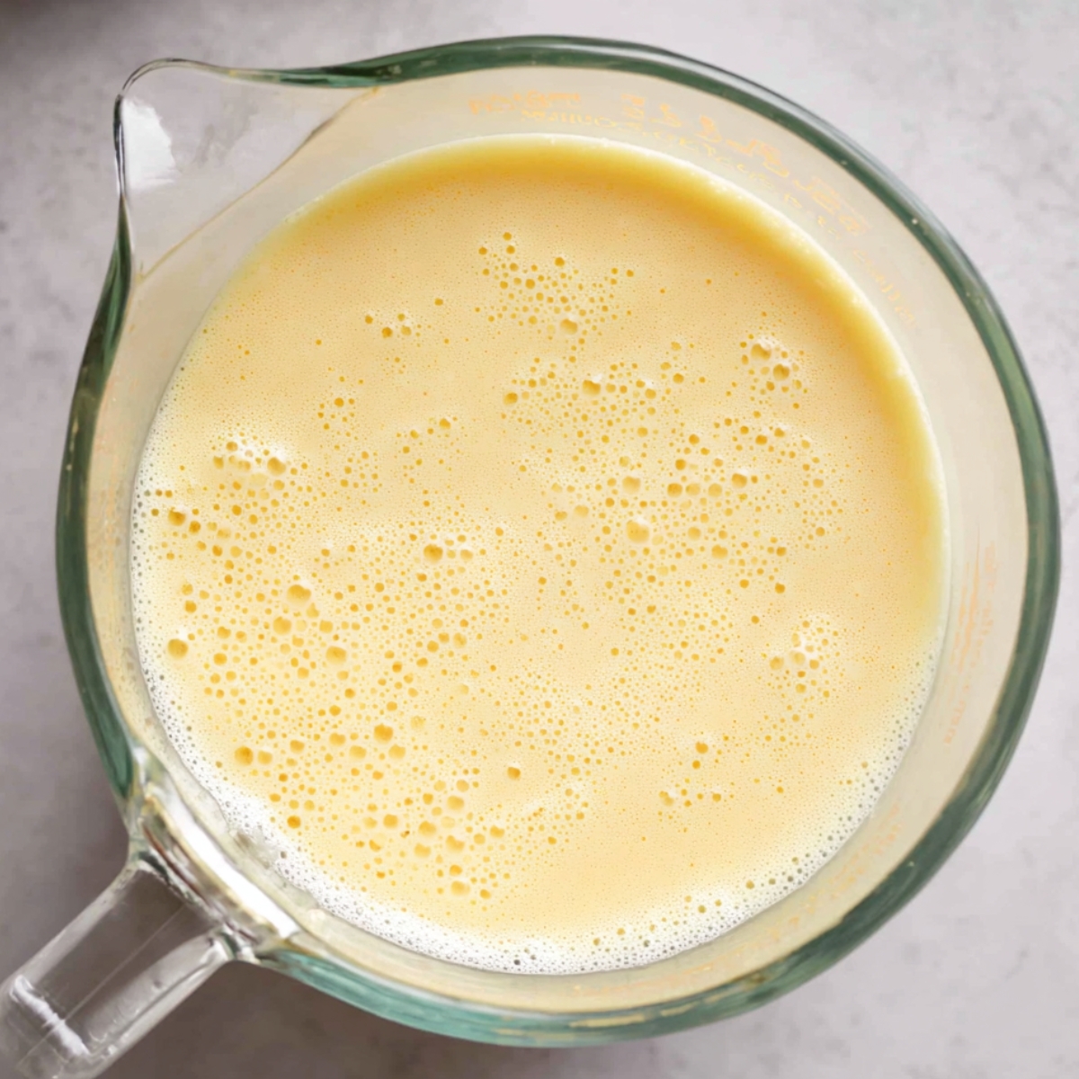 Easy Skillet Brownie Recipe 10 Smooth yellow batter in a glass measuring cup, ready for mixing.