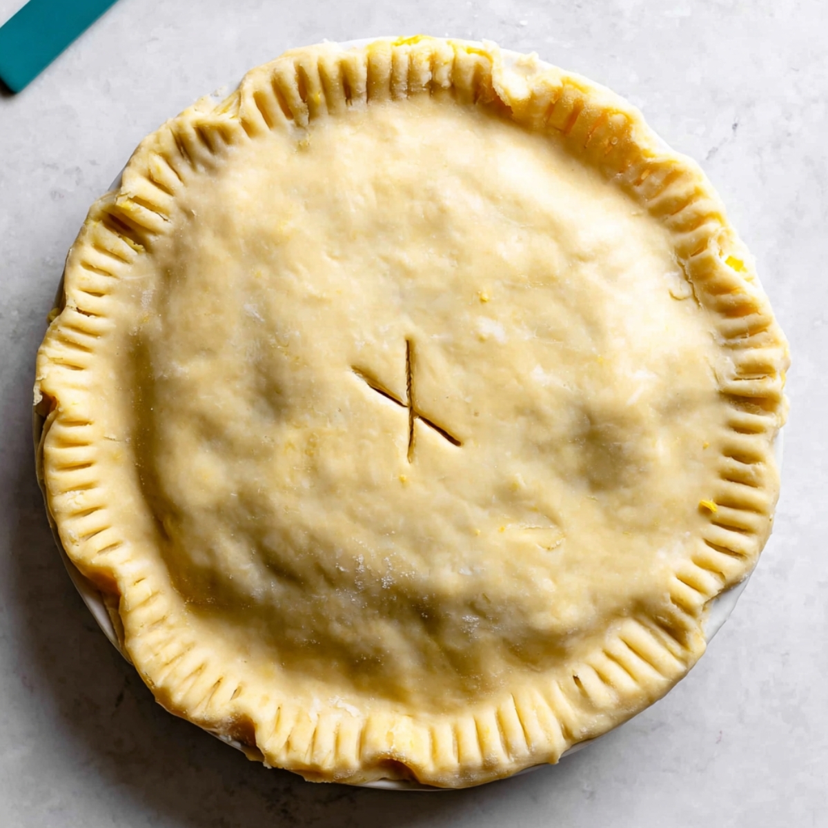 Homemade Leftover Turkey Pot Pie Recipe 11 A freshly baked, golden chicken pot pie with a perfectly crimped crust, and a small X-shaped slit on top for venting.