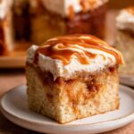A slice of Brown Butter Caramel Cake with frosting and caramel drizzle on top, showcasing the caramel filling inside the moist cake.