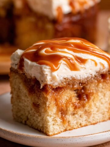 Moist Brown Butter Caramel Cake Recipe 4 A slice of Brown Butter Caramel Cake with frosting and caramel drizzle on top, showcasing the caramel filling inside the moist cake.