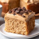 Slice of Brown Sugar Latte Cake topped with coffee frosting and chocolate chunks.