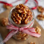Candied Walnuts in a jar, tied with a red-and-white striped ribbon.