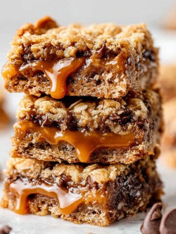Carmelitas Recipe: Easy Caramel Chocolate Cookie Bars 2 Three Carmelitas Recipe stacked on top of each other, with gooey caramel and chocolate chips oozing out between layers of crumbly oat crust.