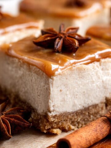 Easy Chai Cheesecake Bars Recipe 2 Chai Cheesecake Bars with a cinnamon caramel topping, garnished with star anise.