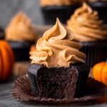 Chocolate Pumpkin Cupcakes with pumpkin frosting and a bite taken out.