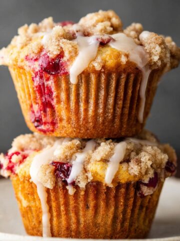 Easy Cranberry Orange Muffins 2 Stack of baked Cranberry Orange Muffins with streusel and glaze.