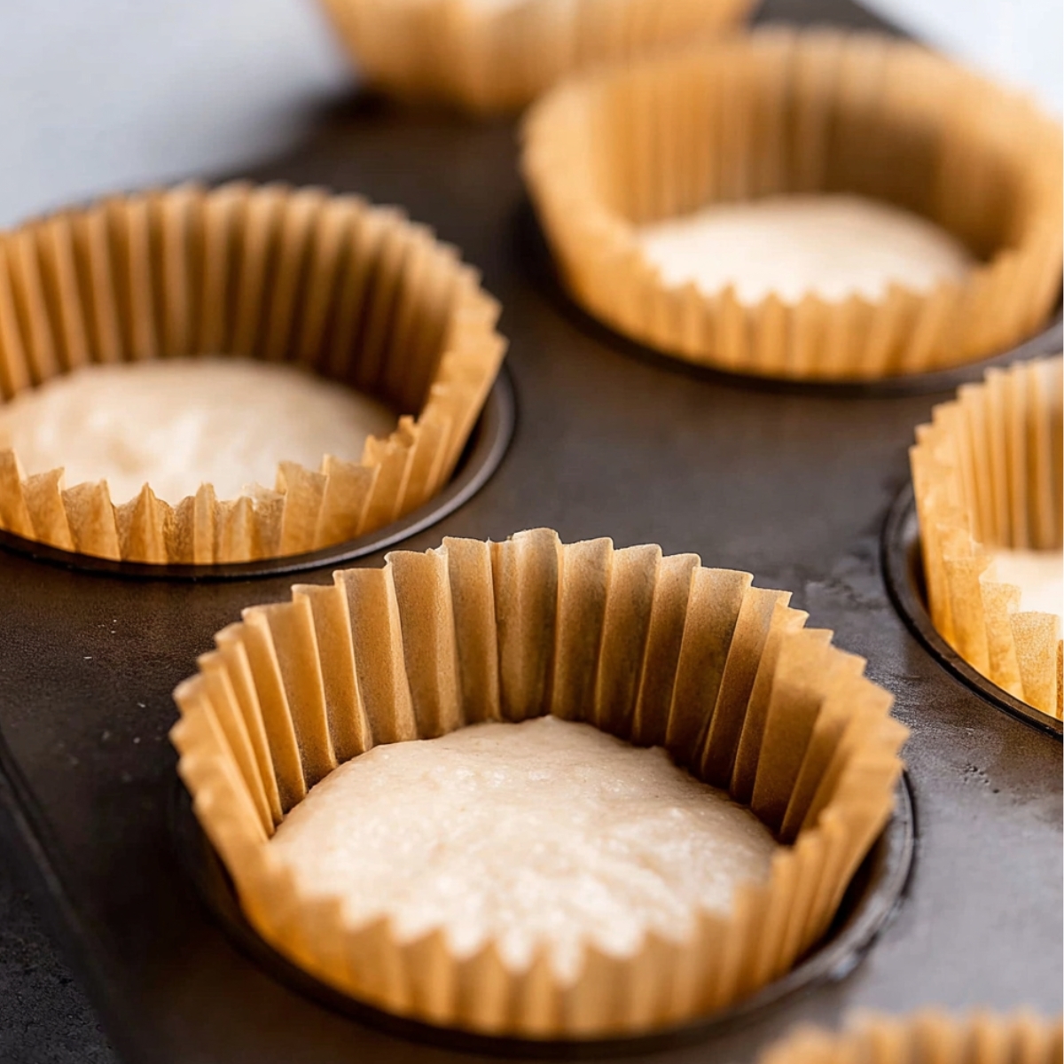 Easy Party Piñata Cupcakes Recipe 11 Muffin cups filled with cupcake batter, ready to be baked.