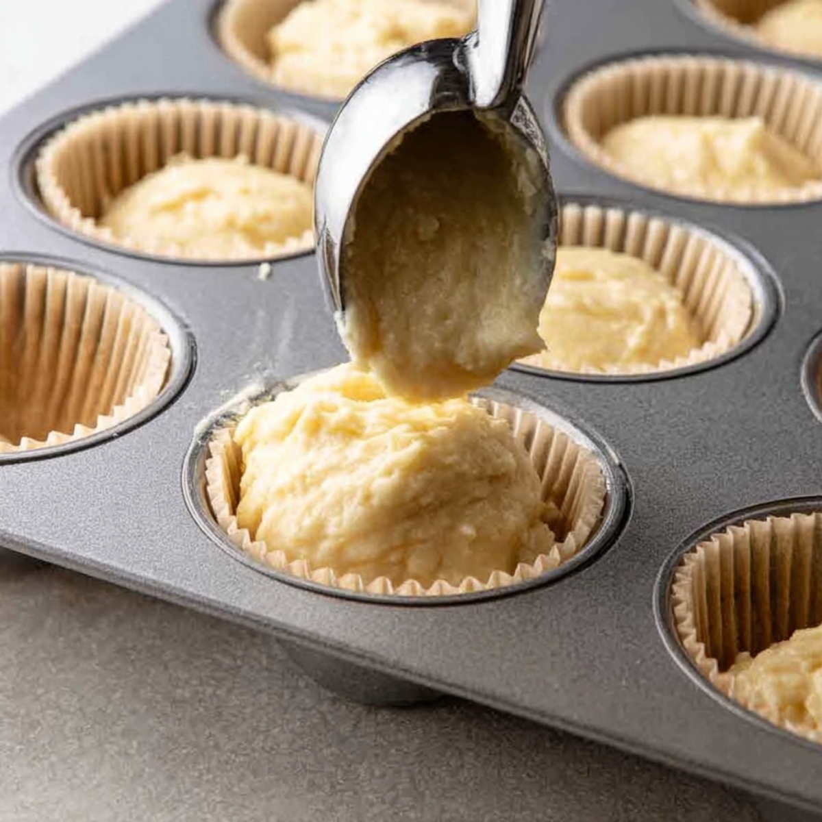 Easy Coconut Cupcakes Recipe 11 Scooping batter into cupcake liners in a muffin tin.