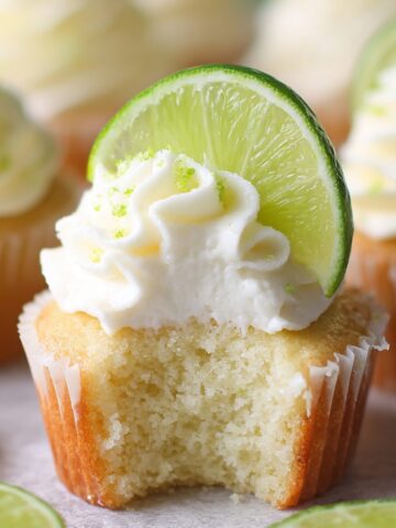 Easy Key Lime Cupcakes Recipe 1 Close-up of a freshly baked Key Lime Cupcakes with a slice of lime and whipped cream.