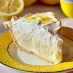 A whole slice of Lemon Angel Pie with lemon zest topping, showing the creamy filling and fluffy meringue.