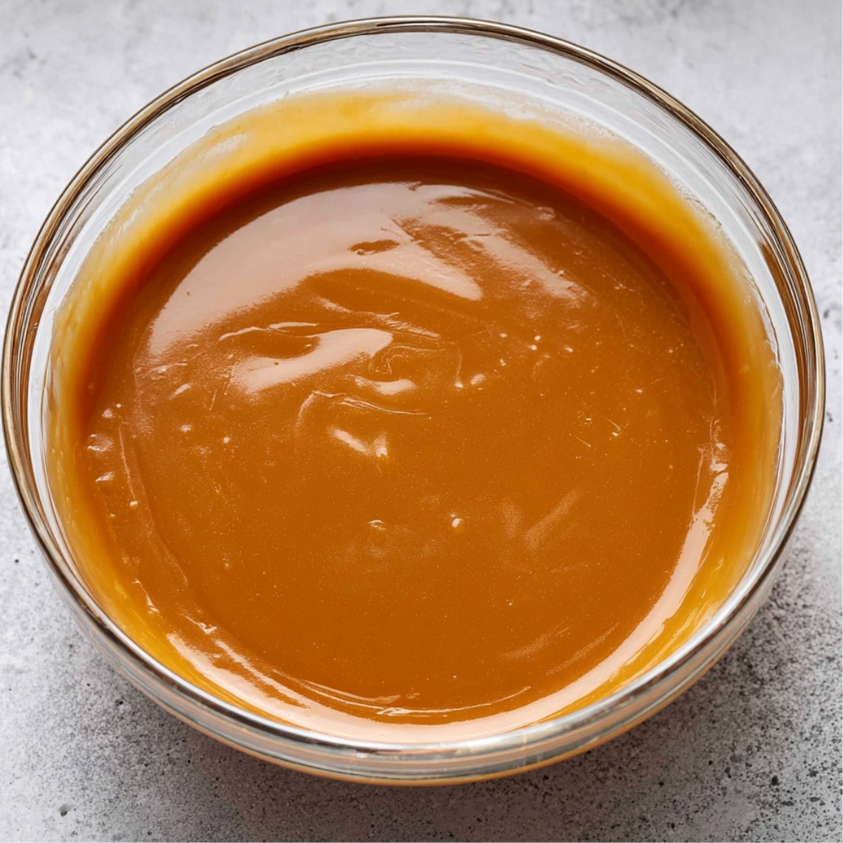 Carmelitas Recipe: Easy Caramel Chocolate Cookie Bars 10 Smooth and glossy homemade caramel filling in a glass bowl, ready to be poured over a dessert.