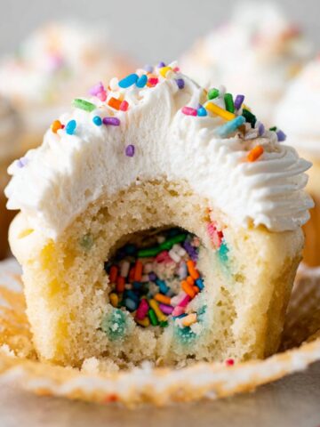 Easy Party Piñata Cupcakes Recipe 2 A Party Piñata Cupcakes with a white frosting topping, filled with colorful sprinkles inside.