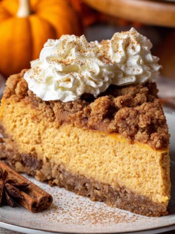 Easy Pumpkin Streusel Cheesecake Recipe 2 A slice of decadent Pumpkin Streusel Cheesecake topped with whipped cream, cinnamon, and a sprinkle of crunchy streusel topping, served with cinnamon sticks and star anise.