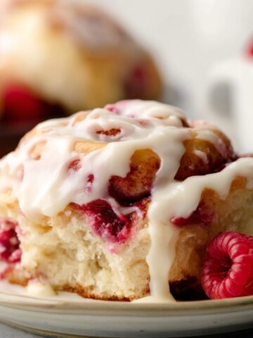 A top-down view of Raspberry Swirl Sweet Rolls arranged neatly in a baking pan, the soft dough swirled with vibrant red raspberry filling, ready to be baked.