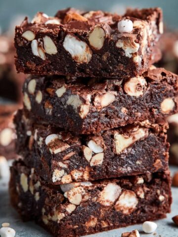A stack of delicious Rocky Road Brownies made with marshmallows, almonds, and chunks of chocolate, showcasing their rich, fudgy texture and mix-ins.