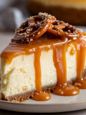 Best Salted Caramel Cheesecake 1 A slice of creamy Salted Caramel Cheesecake with a pretzel crust, drizzled with rich caramel sauce and topped with crunchy pretzels.