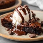 Warm Skillet Brownie topped with vanilla ice cream and chocolate drizzle.