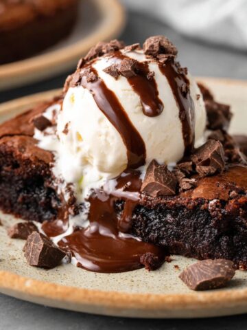 Warm Skillet Brownie topped with vanilla ice cream and chocolate drizzle.