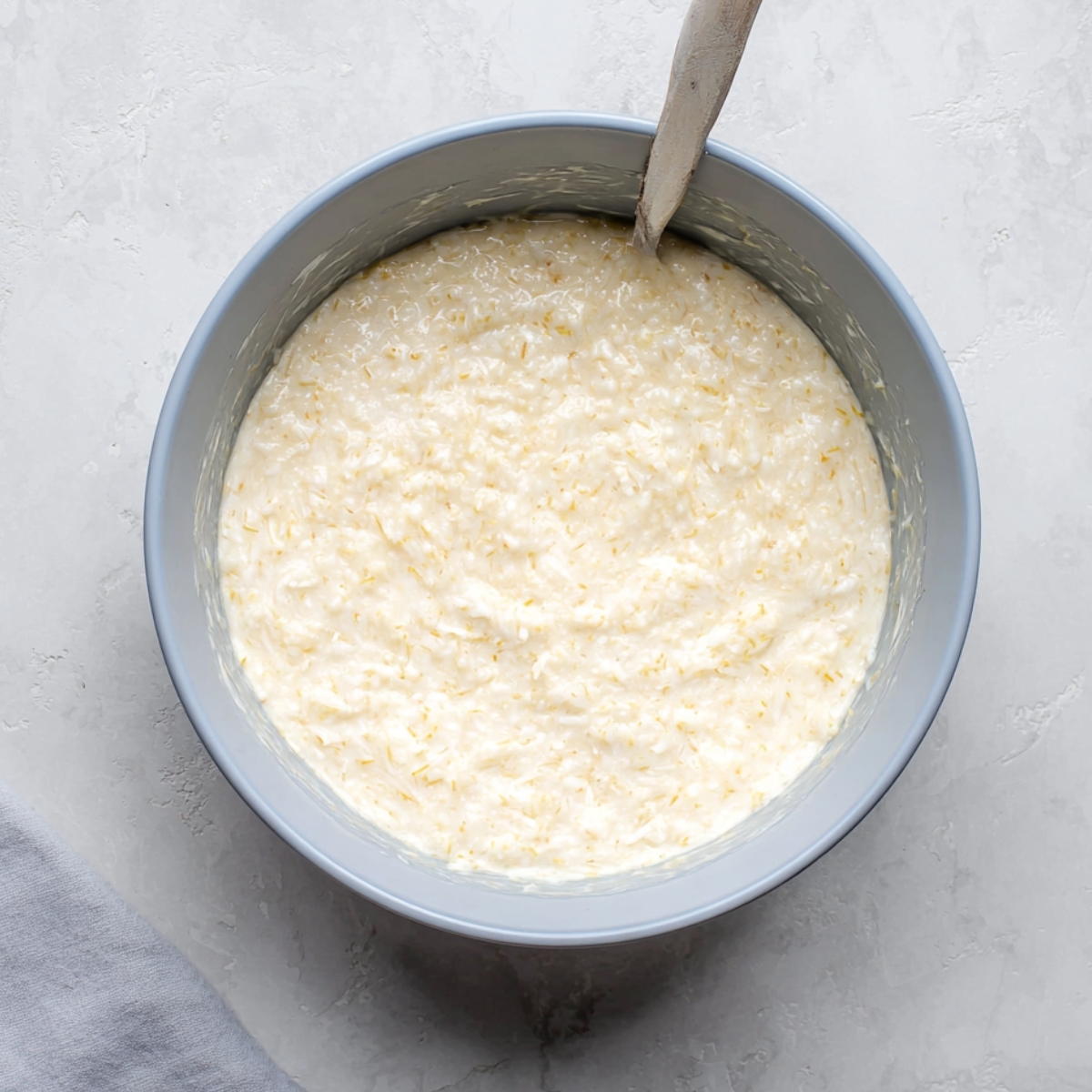 Easy Impossible Coconut Pie Recipe 11 A bowl filled with a creamy coconut pie mixture, ready to be poured into the crust for baking.