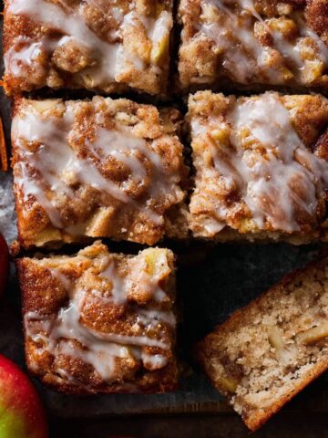 Easy Apple Fritter Cake Recipe 1 Baked Apple Fritter Cake cut into squares, showing glazed top and apple chunks inside.