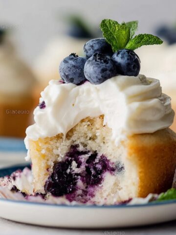 Blueberry Cream Cupcakes Recipe 1 Bite-sized Blueberry Cream Cupcakes with frosting, blueberries, and mint.