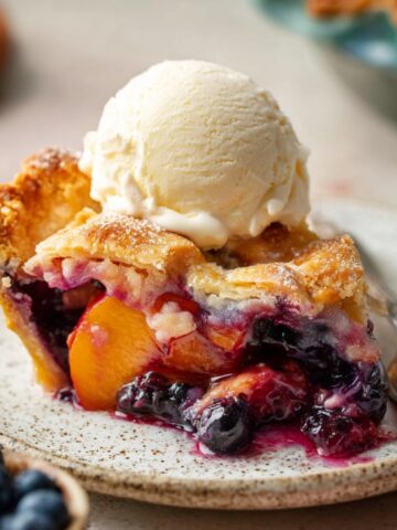 Easy Blueberry Peach Pie Recipe 1 A freshly baked Blueberry Peach Pie with a golden lattice crust, filled with juicy fruit, and ready to be served. The crust is sprinkled with sugar for a sparkling finish.