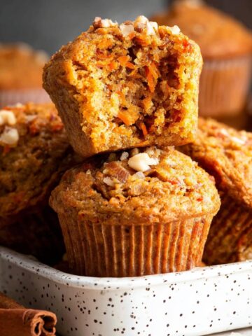 The Best Carrot Muffins Recipe 1 Freshly baked Carrot Muffins in a baking dish with visible carrot and nuts.