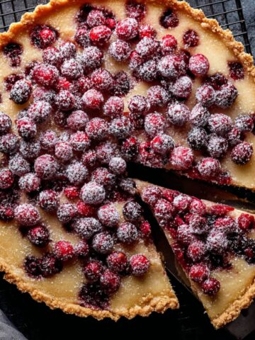 Easy Cranberry Frangipane Tart 1 Unbaked cranberry frangipane tart with fresh cranberries arranged over almond filling in a crumb crust tart shell.