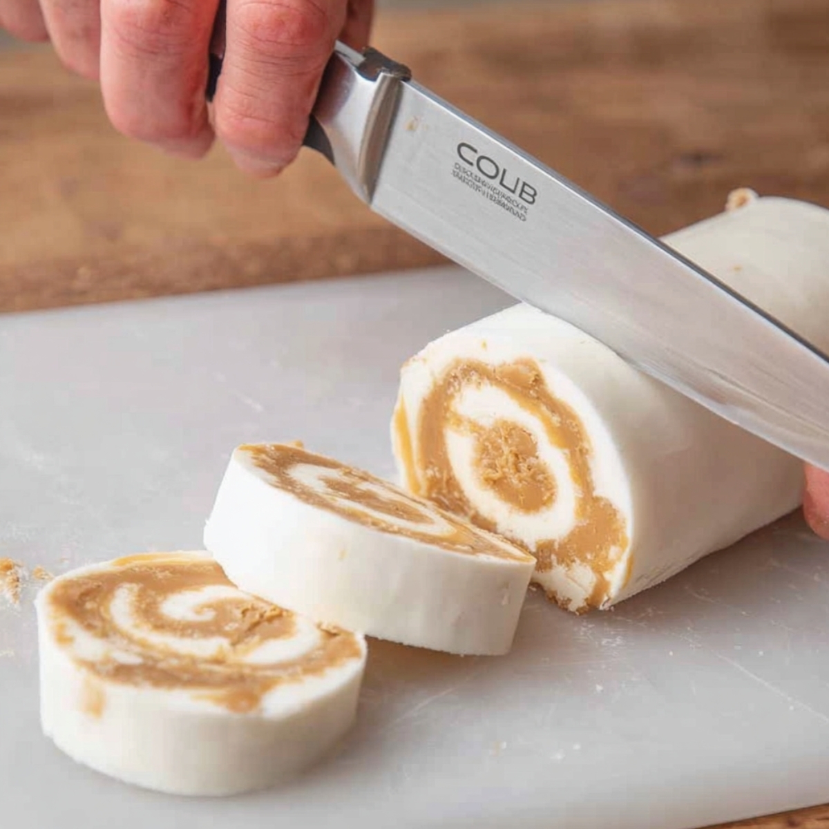 The Best Potato Candy Recipe 11 A plate with festive Christmas-themed design, featuring potato candy rolled into slices with peanut butter center.