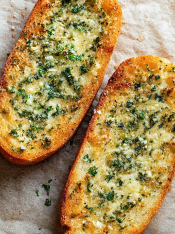 Easy Homemade Garlic Bread Recipe 1 Golden baked Garlic Bread with melted herb butter and parsley, crispy edges, close-up, photorealistic