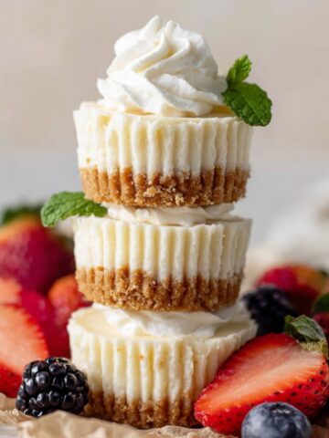 Easy Mini Cheesecakes Recipe 1 Stacked Mini Cheesecakes with berries and whipped cream.