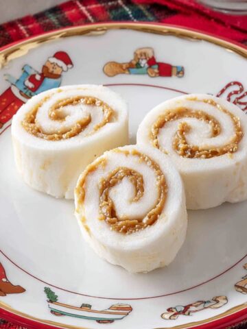 The Best Potato Candy Recipe 1 Sliced potato candy pieces on a plate, showcasing the spiral of peanut butter in each slice.