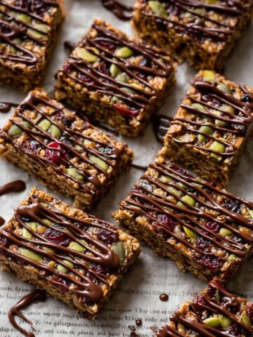 Salted Quinoa Granola Bars drizzled with chocolate on parchment paper.