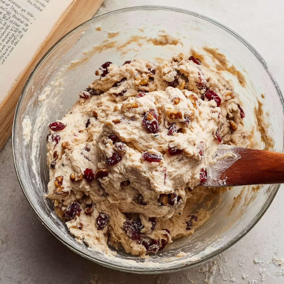 Cranberry Nut No-Knead Bread Recipe 11 Cranberry walnut bread dough in a glass bowl, with dried cranberries and walnuts visible.