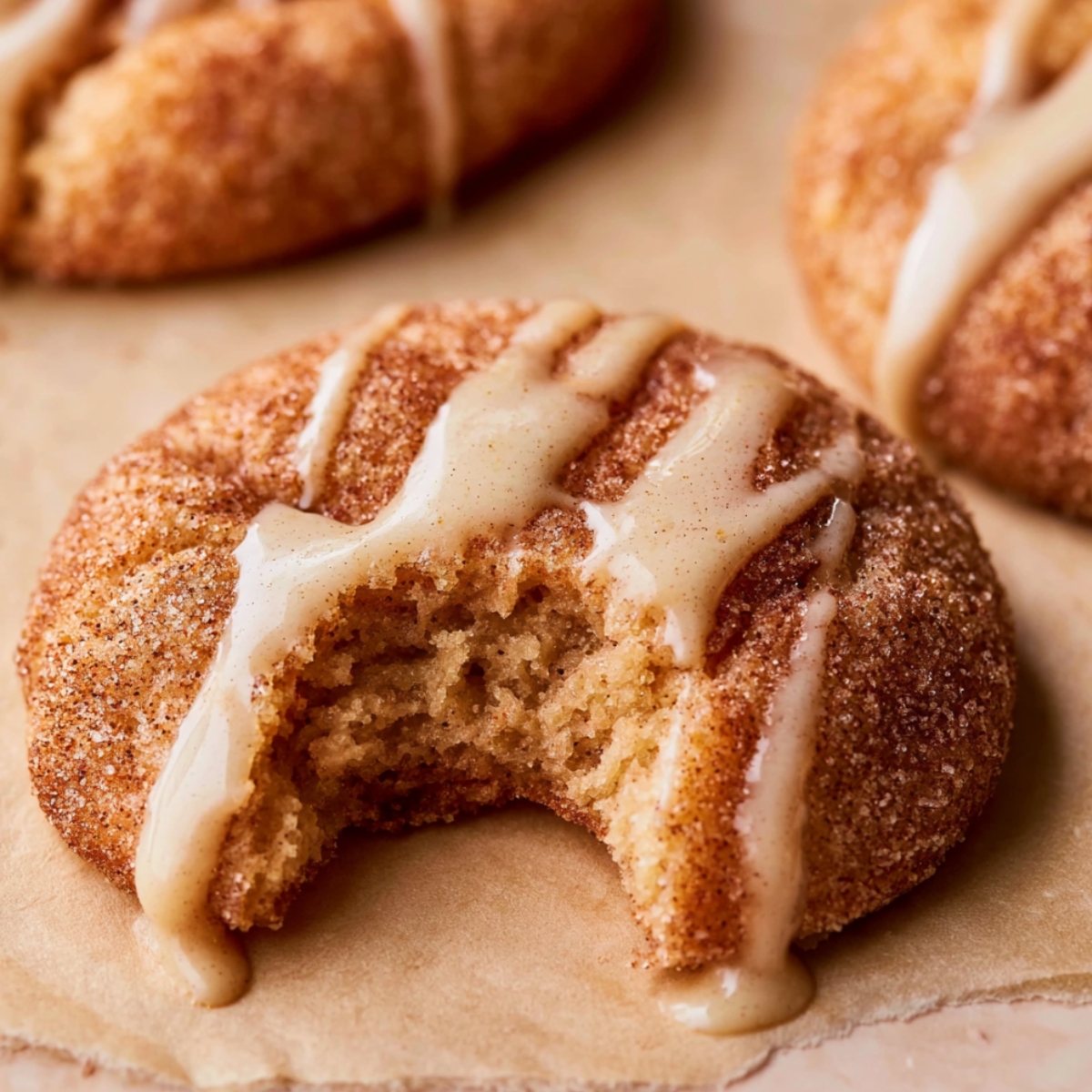 Bite taken from a soft Apple Cider Cookies coated in cinnamon sugar and drizzled with creamy vanilla glaze.
