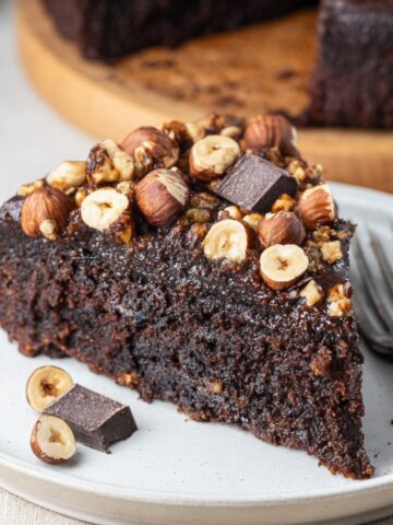 The Best Chocolate Hazelnut Cake Recipe 1 Slice of rich Chocolate Hazelnut Cake topped with roasted hazelnuts and dark chocolate chunks.