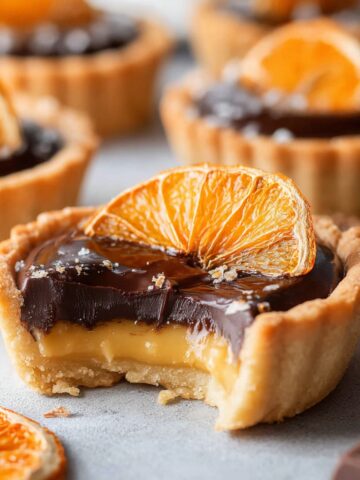 Easy Chocolate Orange Tartlets Recipe 1 Chocolate Orange Tartlets with silky orange curd, rich dark chocolate ganache, and a dried orange slice garnish.