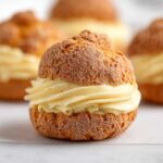 Classic Choux au Craquelin filled with silky vanilla pastry cream and topped with a crisp craquelin crust.