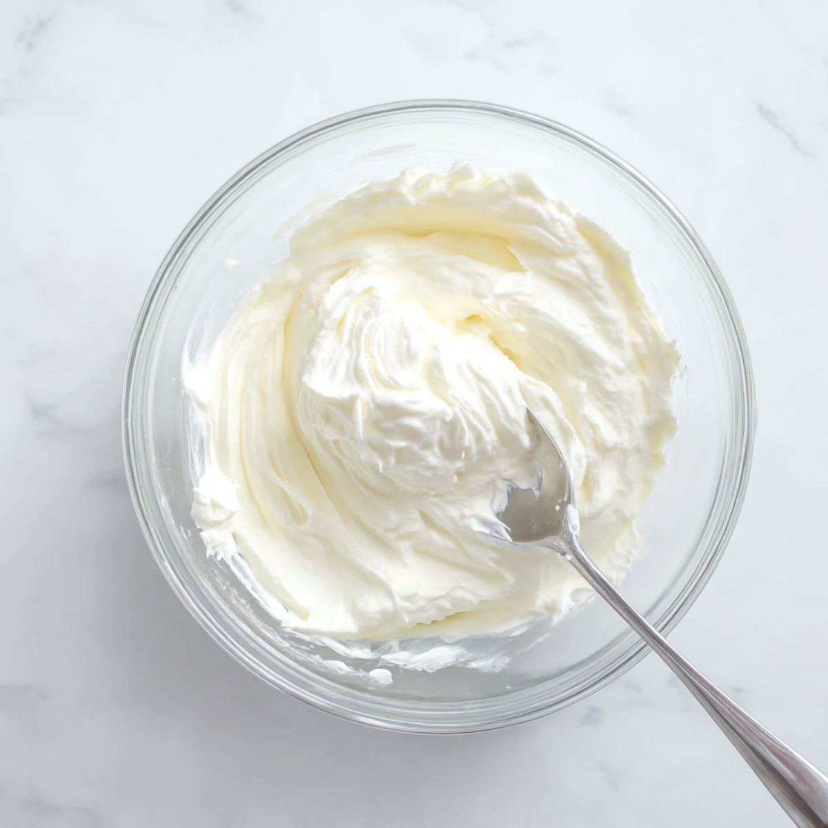 Easy Cream Cheese Banana Muffins 10 Homemade cream cheese filling mixed until smooth in a glass bowl with a spoon for banana muffins.
