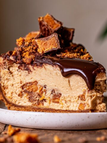 Easy Peanut Butter Butterfinger Pie Recipe 1 Slice of no-bake peanut butter Butterfinger pie with chocolate ganache, graham cracker crust, and crushed Butterfinger candy on a white plate.
