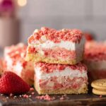 Strawberry Crunch Brownies with a chewy strawberry blondie base, cream cheese frosting, white chocolate chips, and a crunchy strawberry topping.