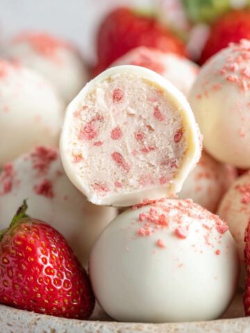 Easy Strawberry Truffles Recipe 2 White chocolate Strawberry Truffles coated in white chocolate and topped with strawberry powder, served with fresh strawberries.