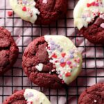 Soft White Chocolate Red Velvet Cookies and decorated with Valentine's Day heart sprinkles on a cooling rack.