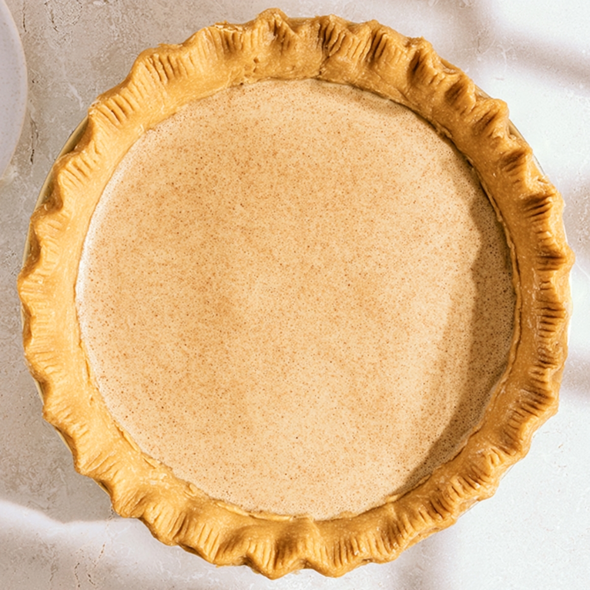 The Best Cinnamon Pie Recipe 11 Unbaked cinnamon pie filling poured into a flaky pie crust before baking.