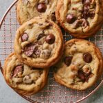 Freshly baked Milk Chocolate Chip Cookies with melted chocolate pieces on a wire cooling rack